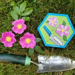 pink wild rose flowers with trowel and hexagon magnet